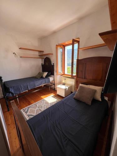 a bedroom with two beds and a window at Il Brolo in Avenone