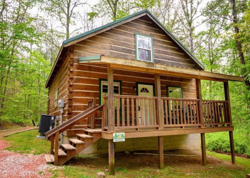 a cabin in the woods with a large deck at Bear Hollow in Logan