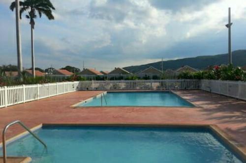 a large swimming pool in the middle of a yard at Caymanas Estate House in Portmore