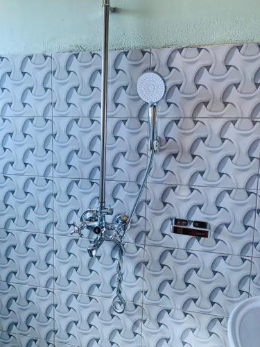 a shower in a bathroom with a tile wall at Highway sunset in Namulanda