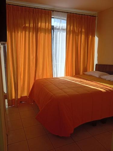 a bedroom with a bed and a window with curtains at Apart Hotel Astore in Antofagasta