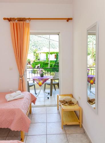 ein Schlafzimmer mit Bett und Tisch und eine Terrasse in der Unterkunft Davis Studios & Apartments - Ήλια Βόρειας Εύβοιας - 1' από τη θάλασσα in Region Ilia