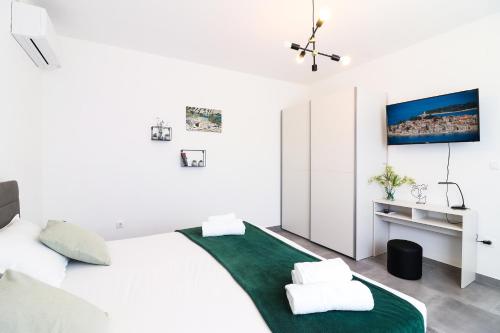 a bedroom with a white bed with a green rug at Apartment Ballin in Primošten