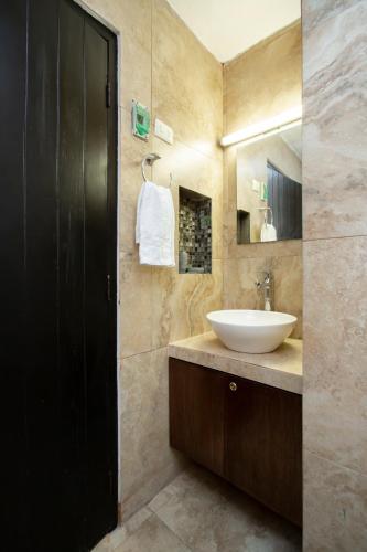 a bathroom with a white sink and a mirror at La Casita Perfect Location in Cozumel