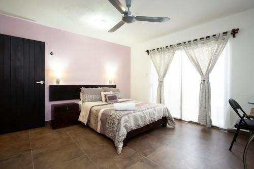 a bedroom with a bed and a ceiling fan at La Casita Perfect Location in Cozumel