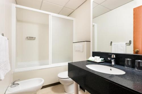バルセロナにあるホテル コンダルのバスルーム(洗面台、トイレ、鏡付)