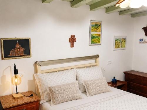ein Schlafzimmer mit einem Bett und einem Kreuz an der Wand in der Unterkunft Loggi House in Kástron