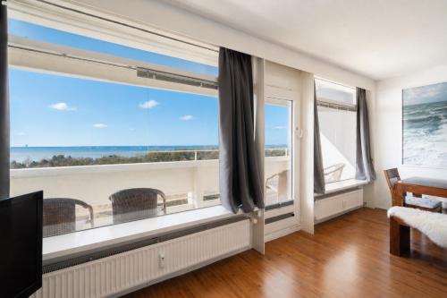 a room with a large window with a view of the ocean at Leuchtturm-Loft mit Meerblick in Sierksdorf