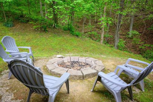 three chairs and a fire pit in a yard at Moonbeam Chalet in Logan