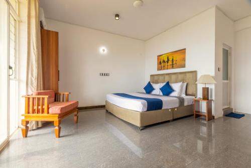 a hotel room with a bed and a chair at Fisherman's Cove in Wattala