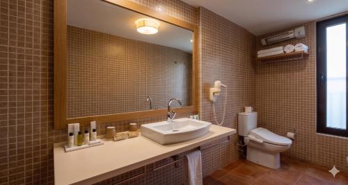 a bathroom with a sink and a toilet and a mirror at Villa Dynamic Els Ports Resort in Arnés