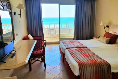 a hotel room with a bed and a desk and a television at Mehari Tabarka in Tabarka