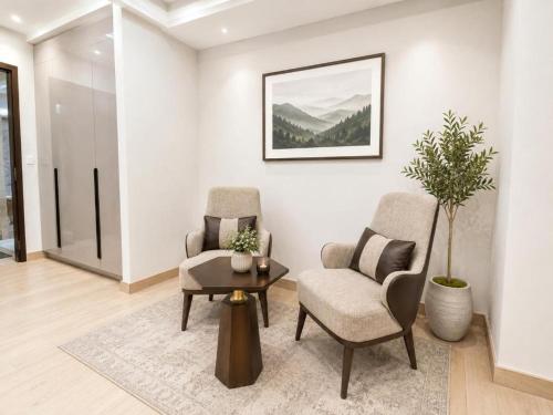 a living room with two chairs and a table at LMY Boutique Prestige Hotel Apartments - Murree Monal Expressway in Murree