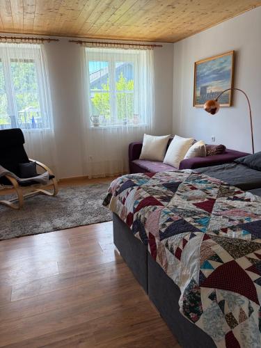 a bedroom with a bed and a couch and windows at Langerhof in Hannersdorf