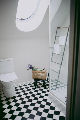 a bathroom with a toilet and a basket of flowers at Flowland Tarczyn in Tarczyn