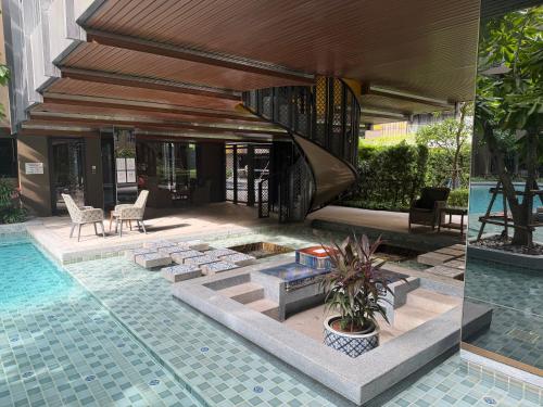 a house with a swimming pool and a patio at A Cozy Condo Near Central-BJ in Ban Rangeng