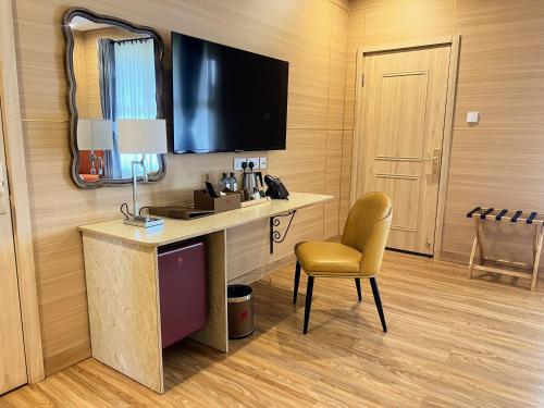 a room with a desk and a chair and a television at Ridge Cabin Resort in Nairobi