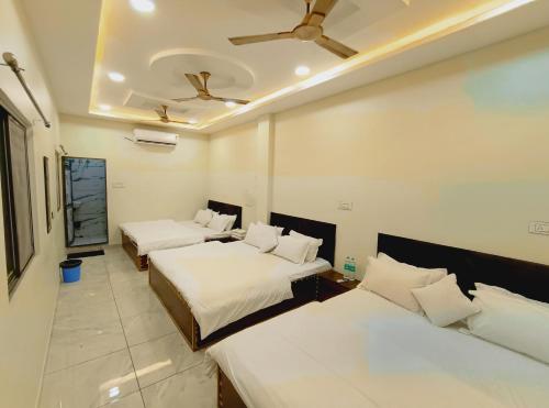 a hotel room with two beds and a ceiling at The Comfort Villa in Ujjain