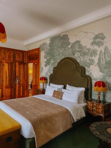 a bedroom with a large bed and a wall mural at Casa do Fontão in Amarante