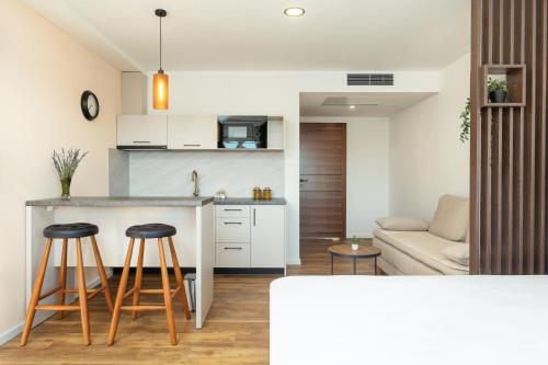 a kitchen and living room with a counter and stools at Apartmani Ivano & Anđelo in Međugorje