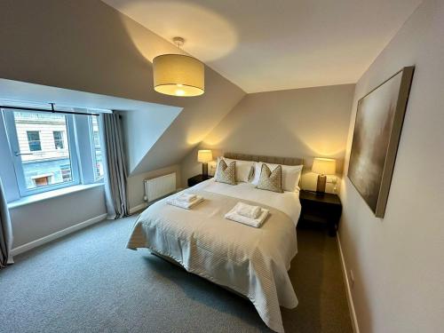 a bedroom with a bed with two lamps and a window at Stay 55 in Peebles