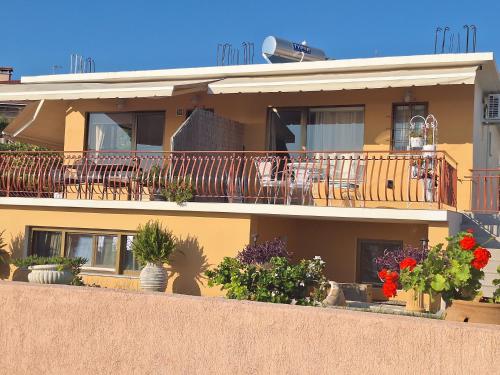 a building with a balcony with tables and chairs at LASSI Apartment 1 in Argostoli