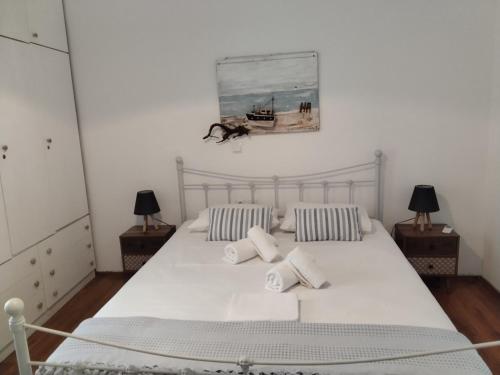 a bedroom with a white bed with two pillows at Sofia’s in Livadi