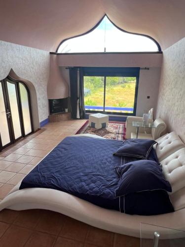 a large bed in a room with a large window at Chez Bouchra suite Royal in Pont Blondin