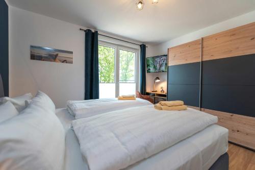a bedroom with a large white bed with a large window at Haffhafen in Garz
