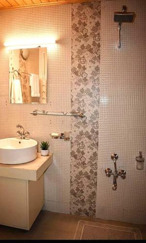 a bathroom with a sink and a mirror at Samoon Guest House Sonmarg in Kulan