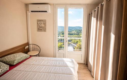 a bedroom with a bed and a large window at Le Chalet Bellevue, Vue Panoramique, Piscine et Clim in Ayen