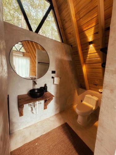a bathroom with a sink and a mirror at Leisy's Garden Cabins & Dorm in Santa Bárbara de Samaná