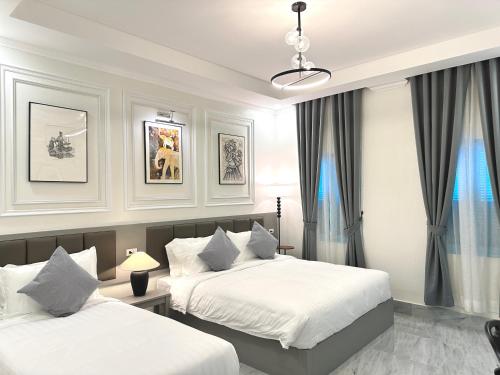 a bedroom with two beds and a window at Luangaloun Guesthouse in Luang Prabang