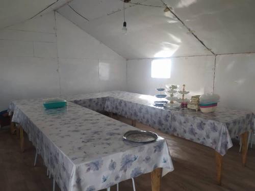 a room with four tables in a white tent at Yurt camp Marat Son-Kul in Song-Kul
