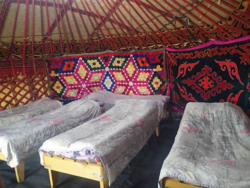 a group of four beds in a yurt at Yurt camp Marat Son-Kul in Song-Kul