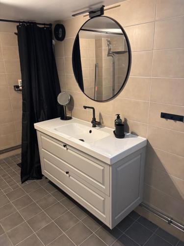 a bathroom with a white sink and a mirror at Gillestugan in Rättvik
