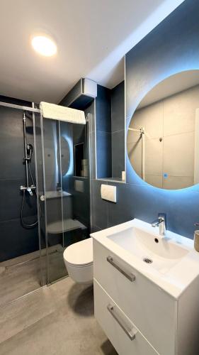 a bathroom with a toilet and a sink and a mirror at Apartments Zanic on The Beach in Podstrana