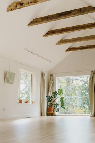 an empty living room with a large window at Le Triangle de l'île - Chambre La Jardin in Saint-Laurent-de-l'ile d'Orleans