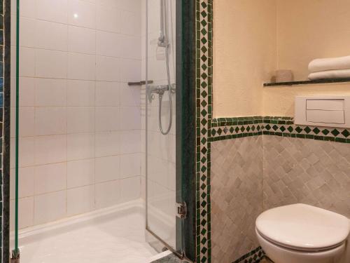 a bathroom with a toilet and a shower at Ibis Meknès in Meknès