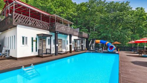 a swimming pool with a slide in front of a house at Ulsan Lime House in Ulsan