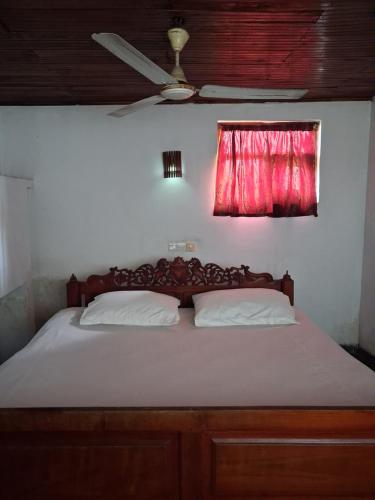 a bedroom with a bed with a red window at Villa Ocean Gift in Galle