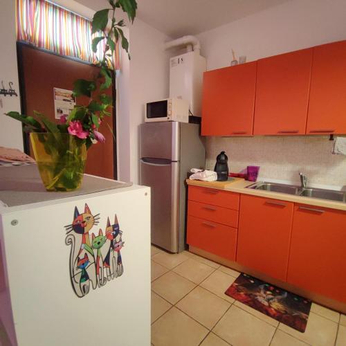 a kitchen with red cabinets and a white refrigerator at Leo House in Trezzo sullʼAdda