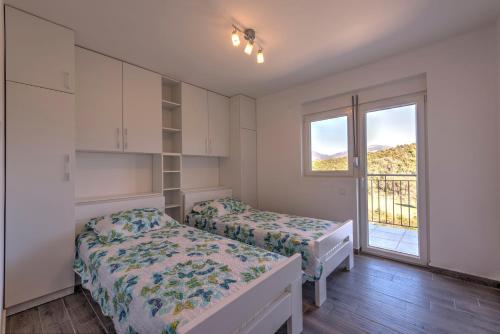 a bedroom with two beds and a window at Villa Sandy Apartments in Tivat