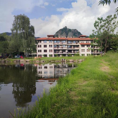 a building next to a body of water at Апартамент "Rodopi" с Гледка към Езеро Безплатен Подземен Гараж in Smolyan