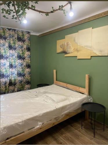 a bed in a room with a green wall at Second&Home 3 in Kalisz