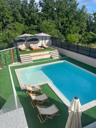 a swimming pool with two lounge chairs and a swimming poolvisor at Villa Bella in Čitluk