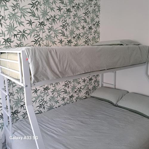 a bunk bed in a room with a wallpaper at LE 37 croix in Gennes