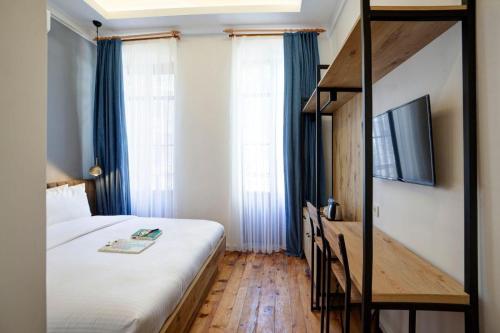 a bedroom with a large bed and a tv at Medusa Historic Luxury Hotel Galata in Istanbul