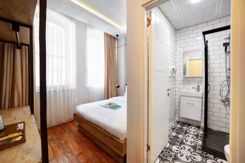 a small bedroom with a bed and a bathroom at Medusa Historic Luxury Hotel Galata in Istanbul