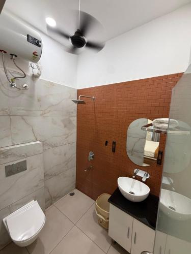 a bathroom with a toilet and a sink and a ceiling fan at Crystal Garden in Lalru